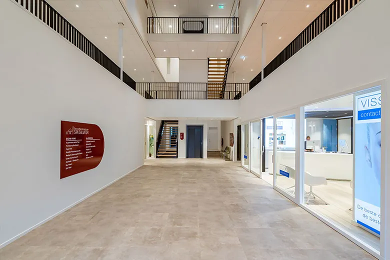 De ruime hal van het gezondheidscentrum, met zicht op de balie